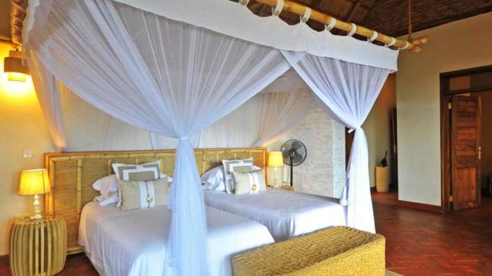 Ein Schlafzimmer mit zwei Betten und weißen Vorhängen