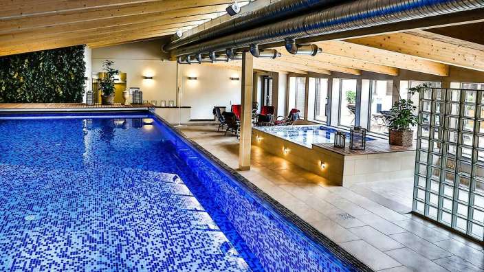 Ein großer Innenpool mit blauem Mosaikboden