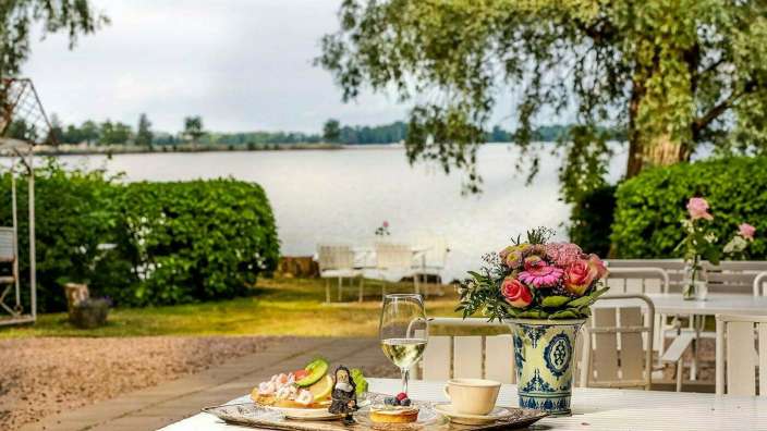 Ein Tisch mit einem Tablett mit Essen und einem Glas Wein darauf