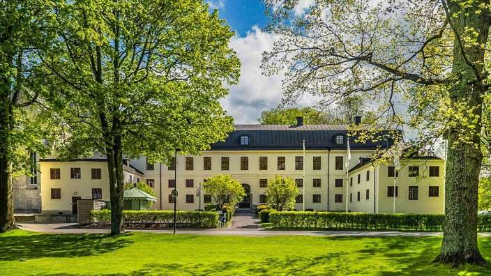 Ein großes Gebäude mit vielen Fenstern und Bäumen davor