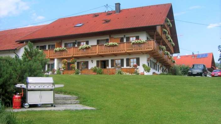 Ein großes Haus mit einem roten Dach und vielen Balkonen