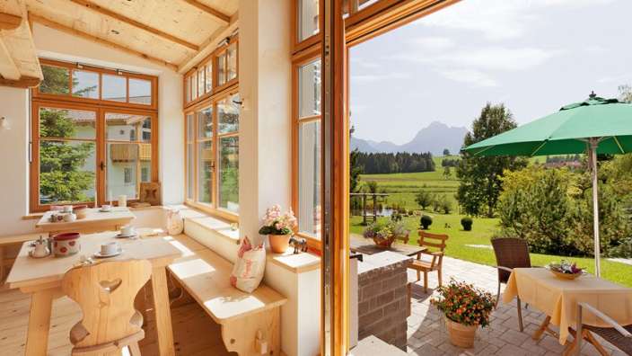 Ein Esszimmer mit einem Tisch und Stühlen und einem grünen Regenschirm