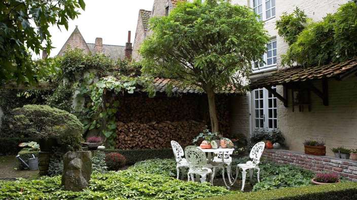 Ein Garten mit einem Tisch und Stühlen vor einem Backsteingebäude