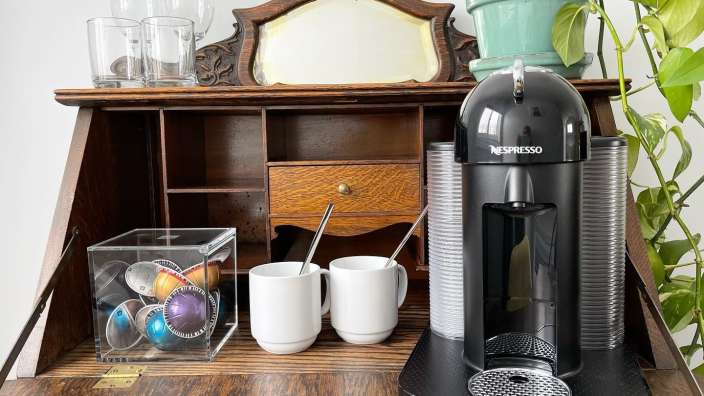 Eine nespresso Kaffeemaschine sitzt auf einem Holztisch