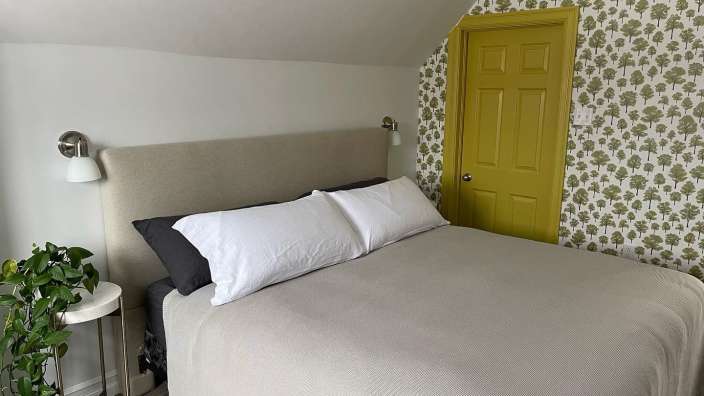 Ein Schlafzimmer mit einem Bett und einer gelben Tür