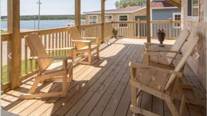 Ein Holzdeck mit Schaukelstühlen und einer Bank