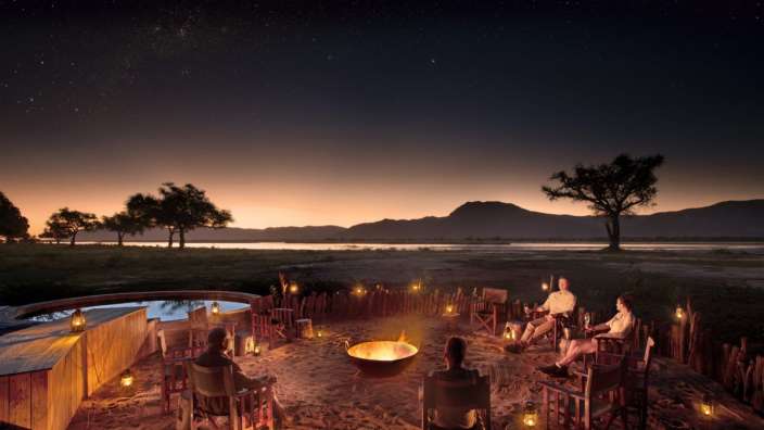 Eine Gruppe von Menschen sitzt um ein Feuer herum