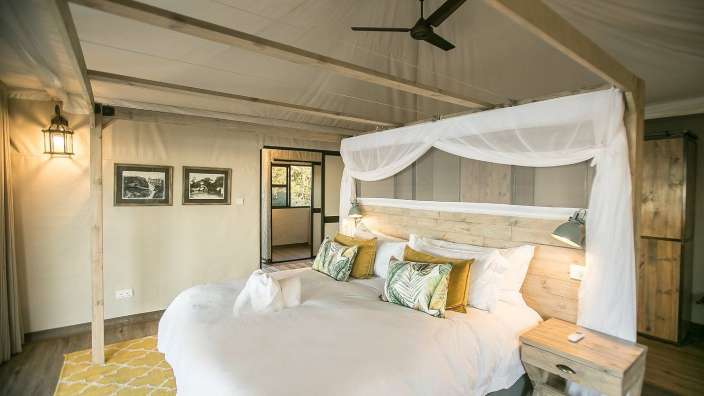 Ein Schlafzimmer mit einem Himmelbett und einem Deckenventilator