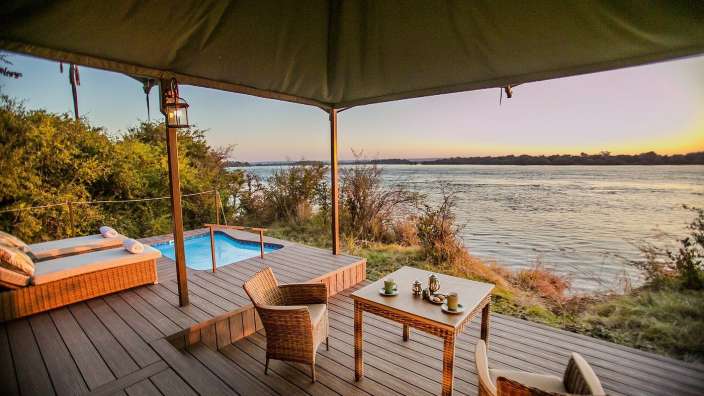 Ein Tisch und Stühle auf einem Deck mit Blick auf einen Fluss