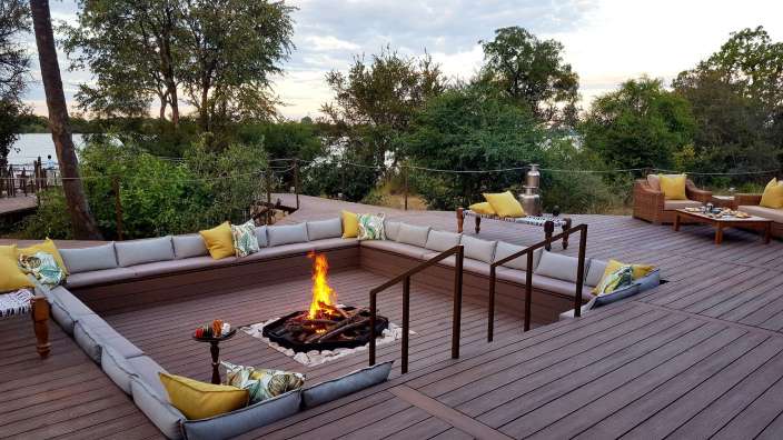 Eine Feuerstelle auf einem Deck mit Couchgarnituren