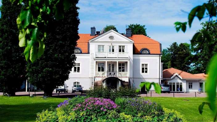 Ein großes weißes Haus mit einem roten Dach