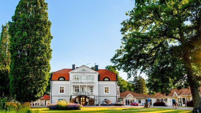 Ein großes weißes Haus mit einem roten Dach