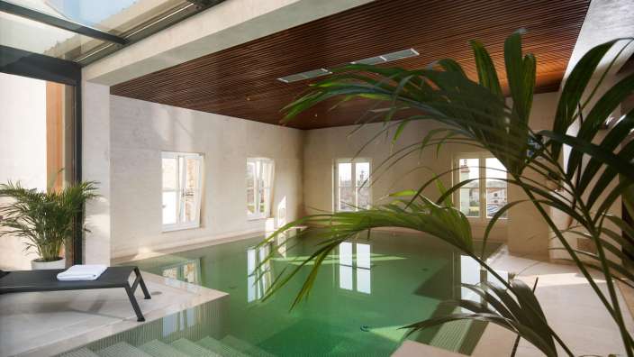 Ein großer Swimmingpool in einem Gebäude mit vielen Fenstern