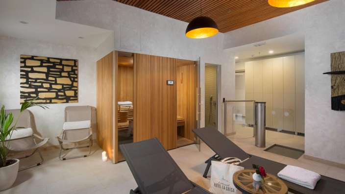 Ein Raum mit Liegestühlen und einer Holzsauna