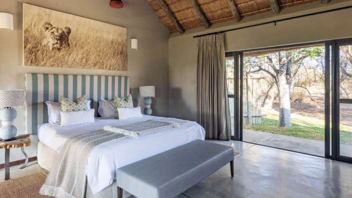 Ein Schlafzimmer mit einem Bett und einem Gemälde eines Löwen darüber