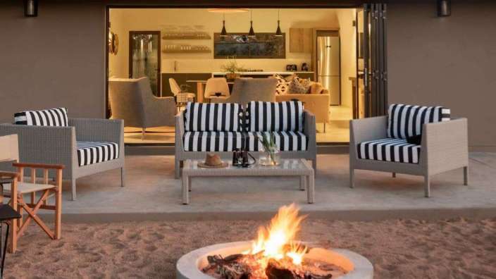 Ein Wohnzimmer mit gestreiften Möbeln und einem Feuer