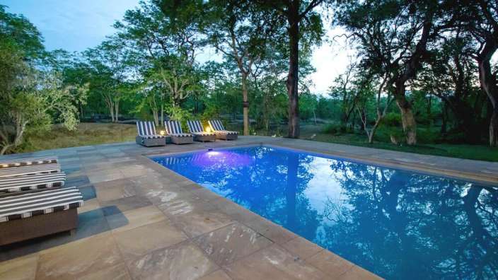 Liegestühle stehen neben einem großen Swimmingpool