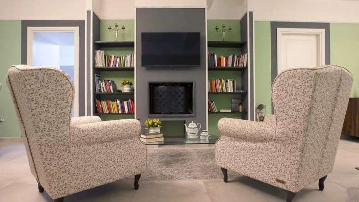 Ein Wohnzimmer mit zwei Stühlen und einem Fernseher