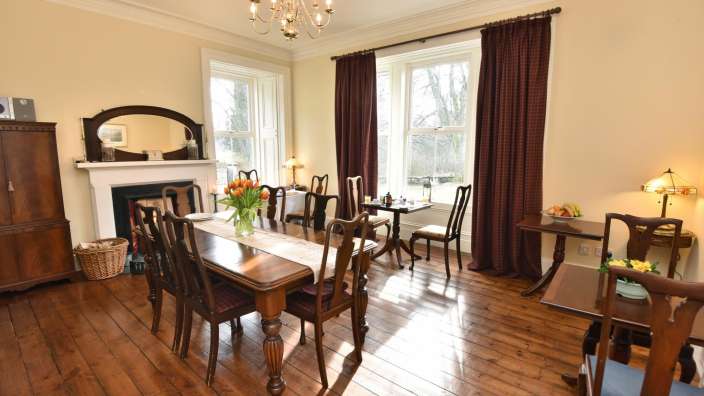 Ein Esszimmer mit einem Tisch und Stühlen und einem Kamin