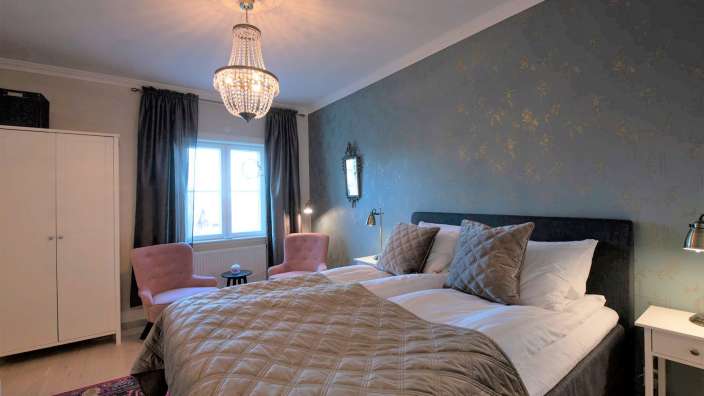 Ein Schlafzimmer mit einem Bett und zwei Stühlen