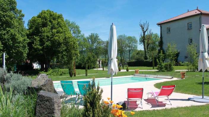 Ein großer Pool mit vielen Stühlen und Sonnenschirmen