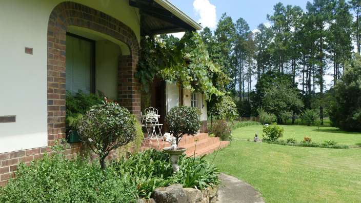 Ein weißes Backsteinhaus mit einem weißen Stuhl davor