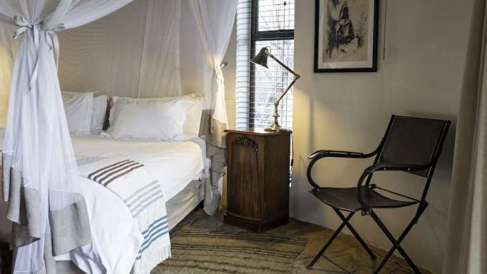 Ein Schlafzimmer mit einem Himmelbett und einem Stuhl