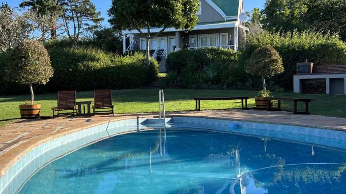 Ein großer Swimmingpool mit einem Haus im Hintergrund