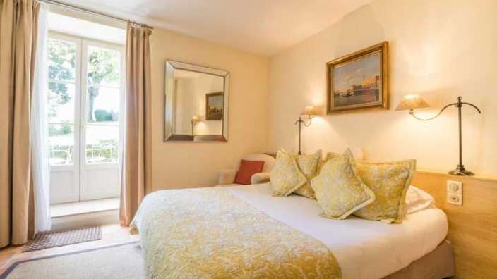 Ein Hotelzimmer mit einem Bett, einem Stuhl und einem Spiegel .