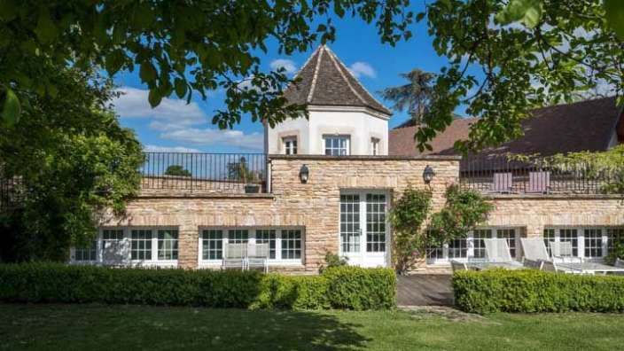 Ein großes Steinhaus mit vielen Fenstern und einem Turm darauf .