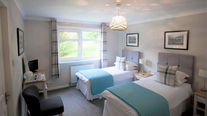 Ein Schlafzimmer mit zwei Einzelbetten und einem Stuhl