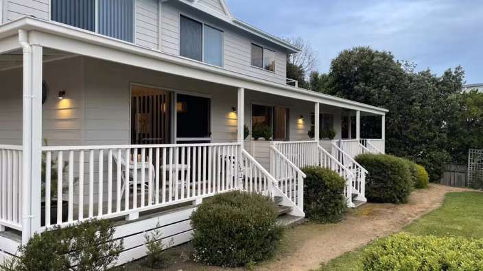 Ein weißes Haus mit einer großen Veranda und Treppe