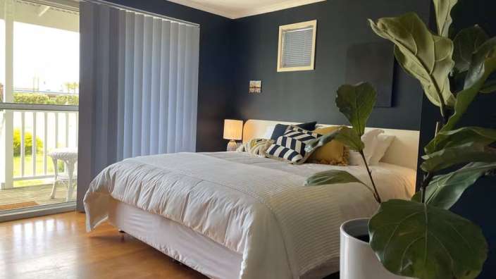 Ein Schlafzimmer mit einem Bett und einer Pflanze