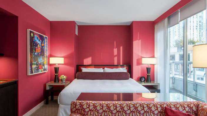 Ein Hotelzimmer mit roten Wänden und einem Bett