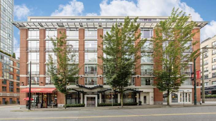 Ein großes Backsteingebäude mit vielen Fenstern und einem Restaurant davor