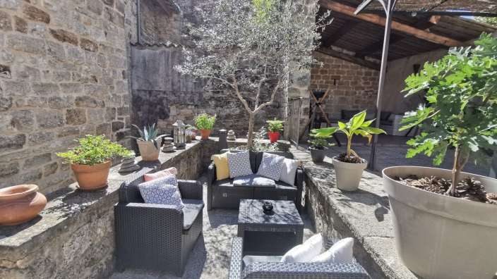 Eine Terrasse mit Möbeln und Pflanzen an einem sonnigen Tag