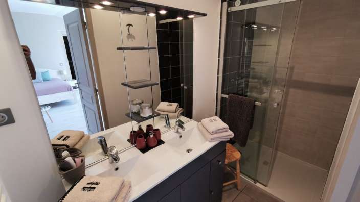 Ein Badezimmer mit einem Waschbecken und einem Duschraum