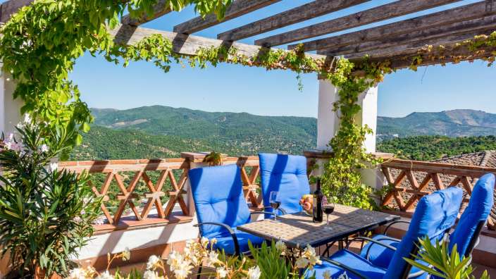 Ein Tisch und Stühle auf einem Balkon mit Blick auf die Berge