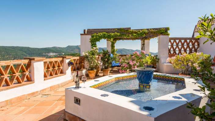 Ein Brunnen auf einem Dach mit einem Glas Wein darauf