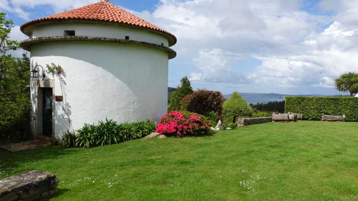 Ein weißes Gebäude mit einem roten Dach sitzt auf einem grünen Rasen
