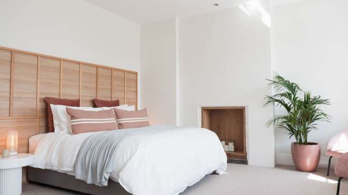 Ein Schlafzimmer mit einem Bett und einer Pflanze