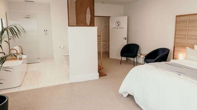 Ein Schlafzimmer mit einem Bett , zwei Stühlen und einer Badewanne