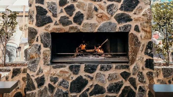 Ein Feuer brennt in einem Kamin aus Stein