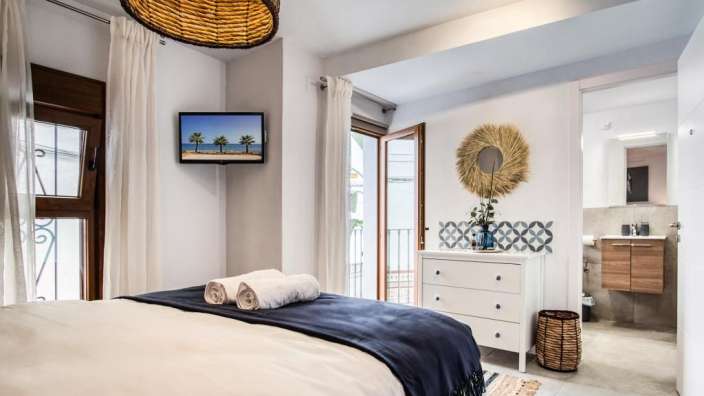 Ein Schlafzimmer mit einem Bett und einem Fernseher an der Wand