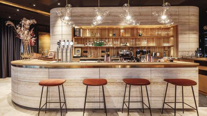 Eine Bar mit Barhockern und Flaschen an der Theke