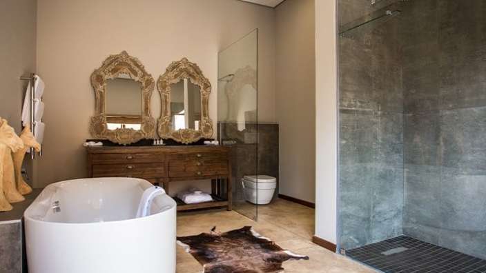 Ein Badezimmer mit einer Badewanne und zwei Spiegeln