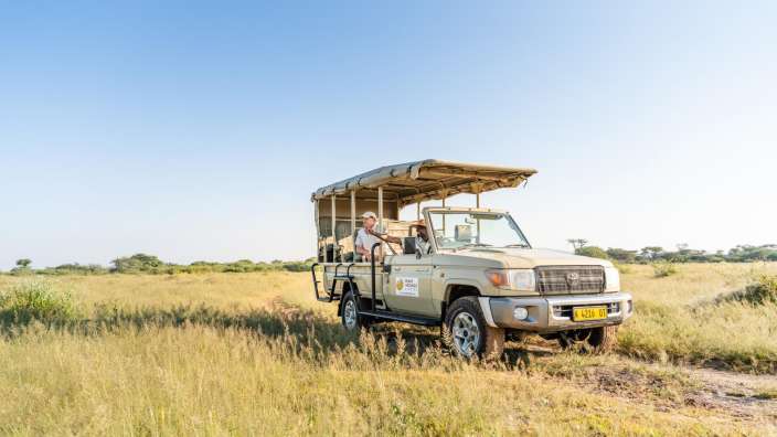Ein toyota-jeep fährt durch ein grasbewachsenes feld