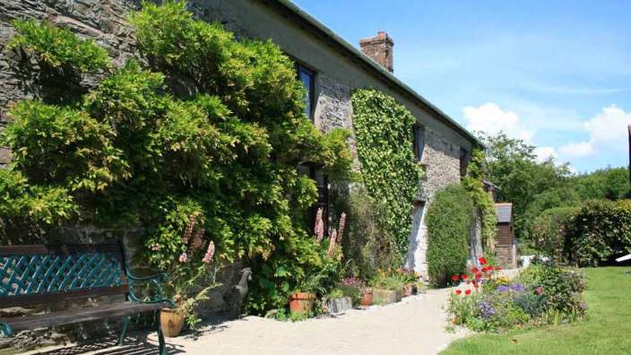 Eine Bank sitzt vor einem großen Steingebäude