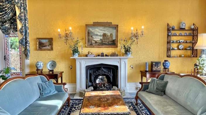 Ein Wohnzimmer mit gelben Wänden und einem Kamin