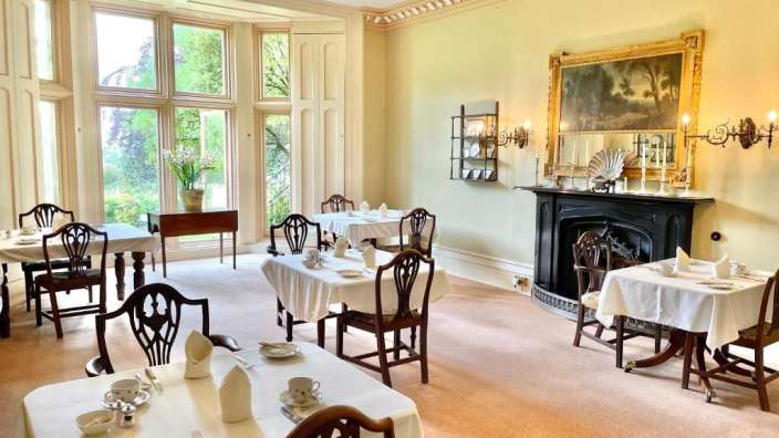 Ein Esszimmer mit Tischen und Stühlen und einem Kamin